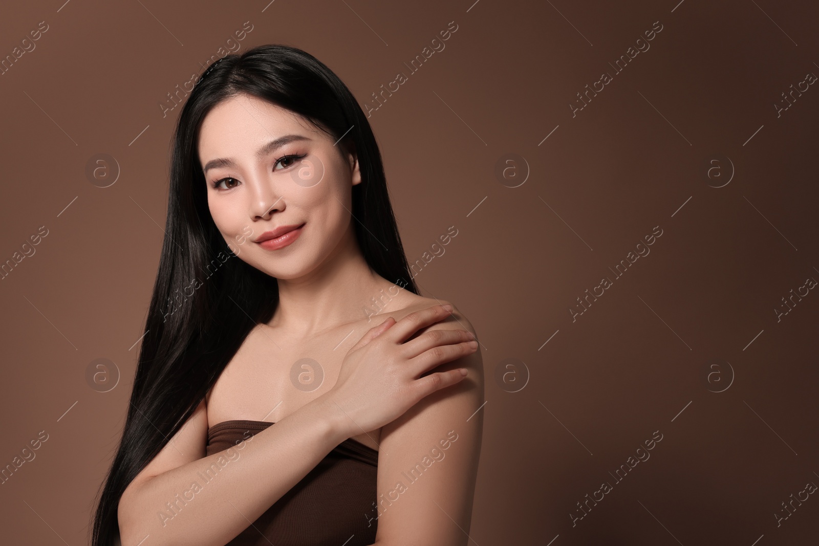 Photo of Portrait of beautiful woman on brown background, space for text