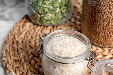 Glass jar with uncooked rice on table