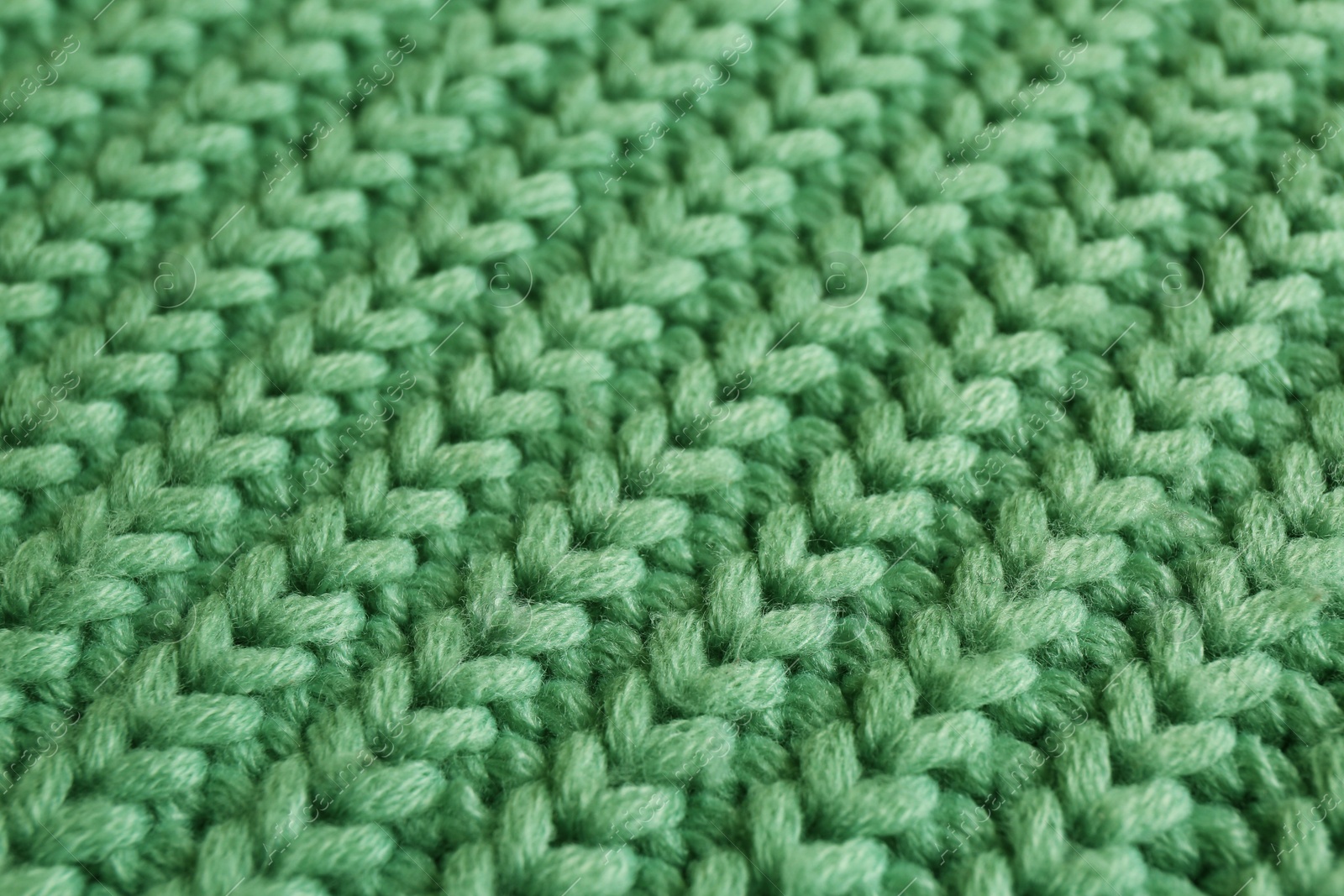 Photo of Beautiful pale green knitted fabric as background, closeup