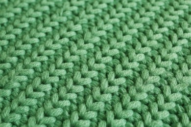 Beautiful pale green knitted fabric as background, closeup