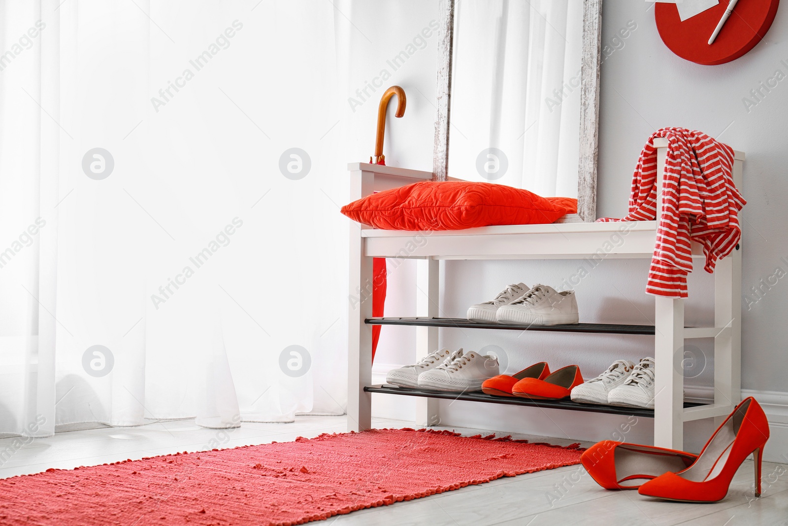 Stylish hallway interior with shoe rack and rug. Space for text Photo of Stylish hallway interior with shoe rack and rug. Space for text