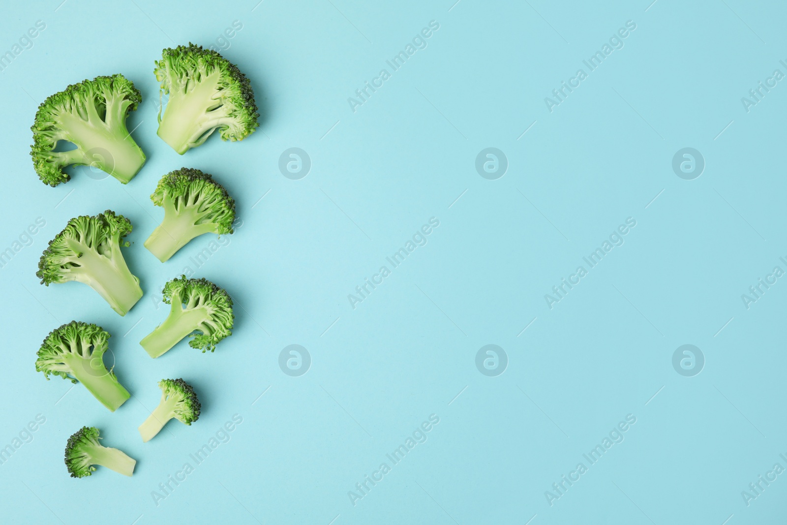 Photo of Flat lay composition with fresh green broccoli on color background. Space for text