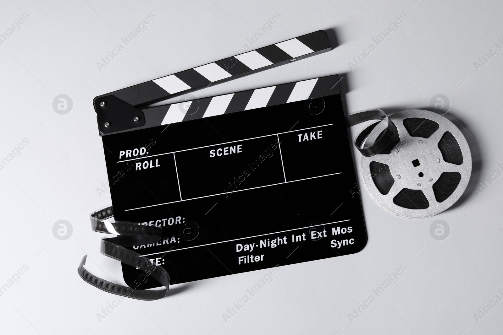 Photo of Clapperboard and film reel on grey background, flat lay