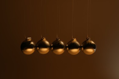Photo of Newton's cradle on brown background. Physics law of energy conservation