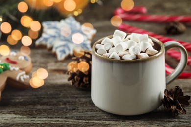 Photo of Delicious hot chocolate with marshmallows and Christmas decor on wooden table, closeup. Space for text
