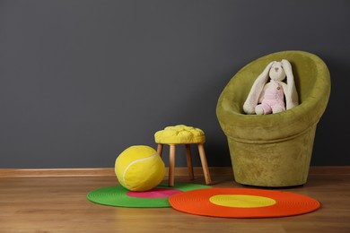 Photo of Child's room interior with comfortable armchair and bunny toy. Space for text