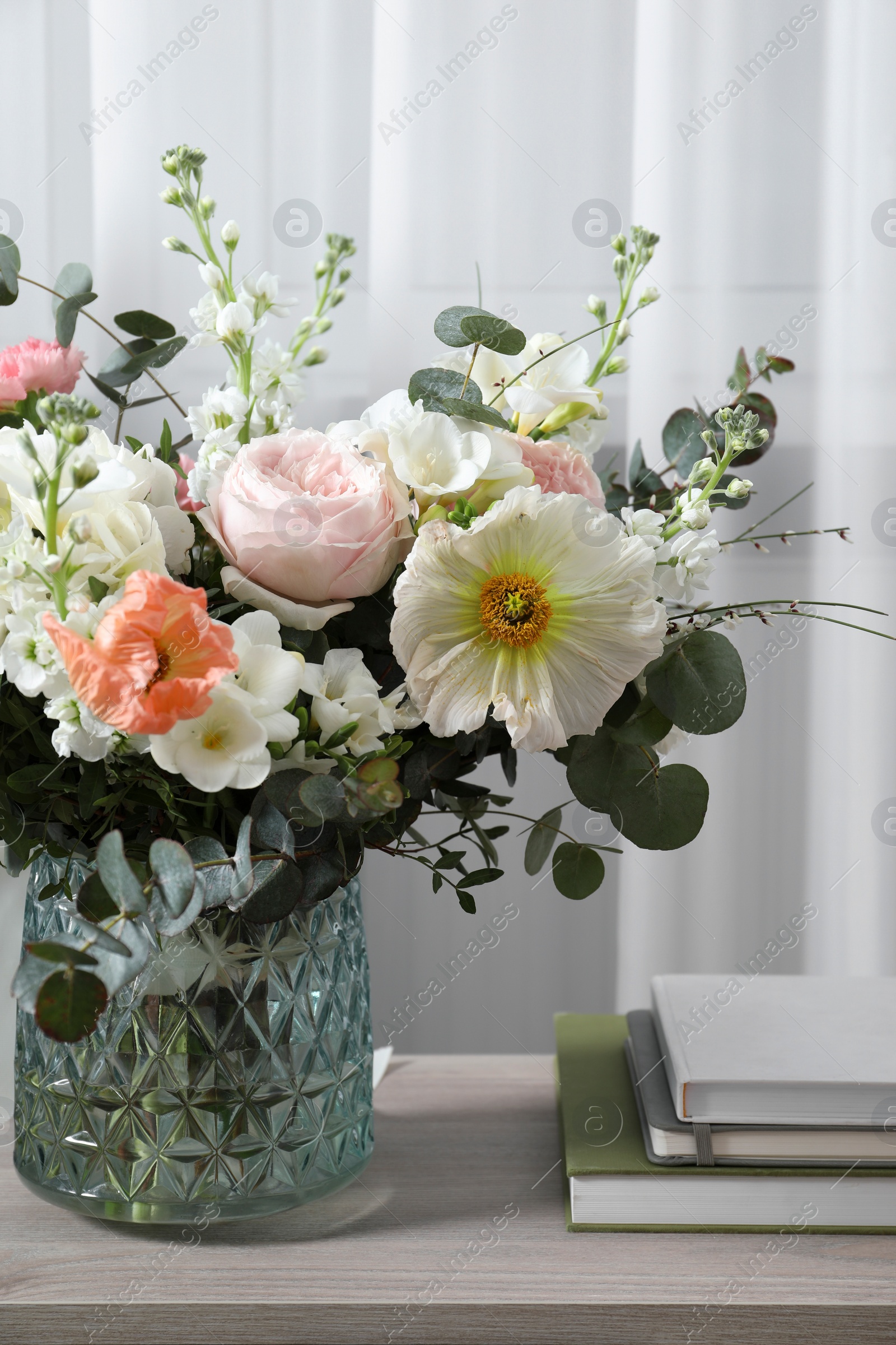 Photo of Bouquet of beautiful flowers on wooden table indoors