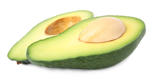 Cut tasty ripe avocados on white background. Tropical fruit