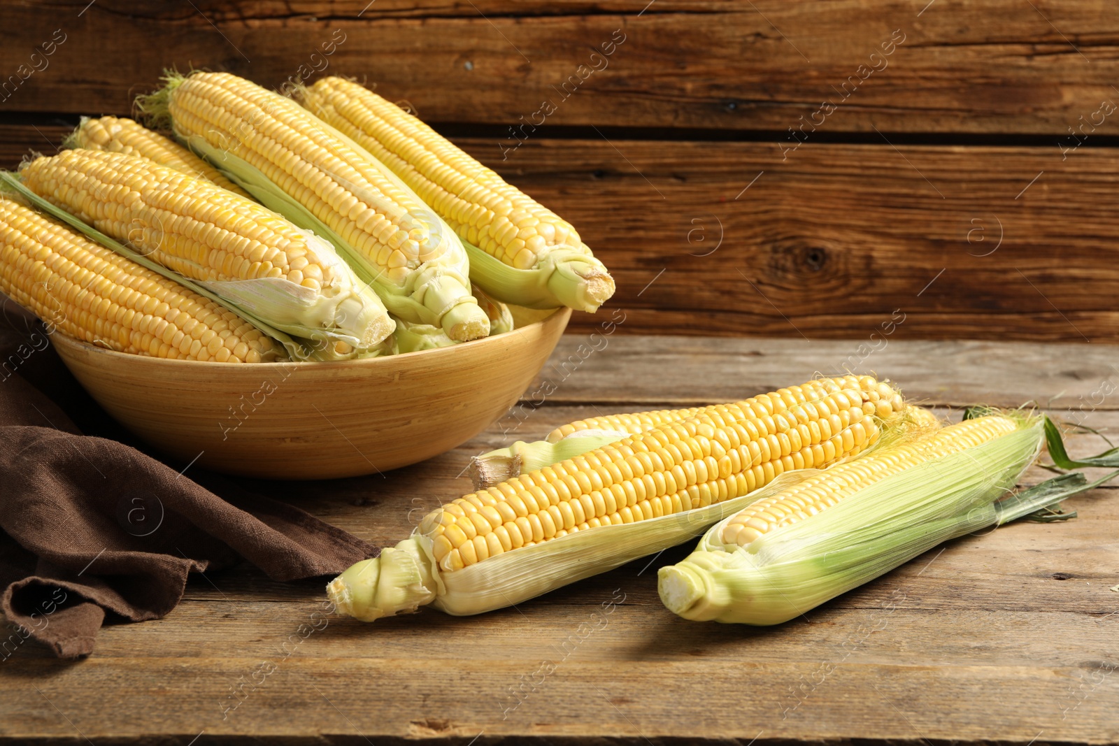 Photo of Tasty sweet corn cobs on wooden table