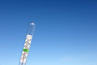 Weather thermometer against blue sky, space for text