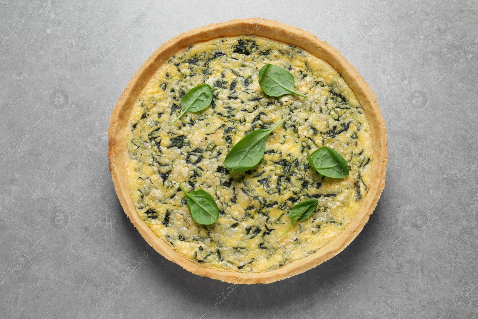 Photo of Delicious homemade spinach pie on light grey table, top view