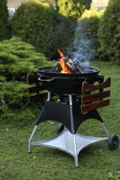 Photo of Portable barbecue grill with fire flames outdoors