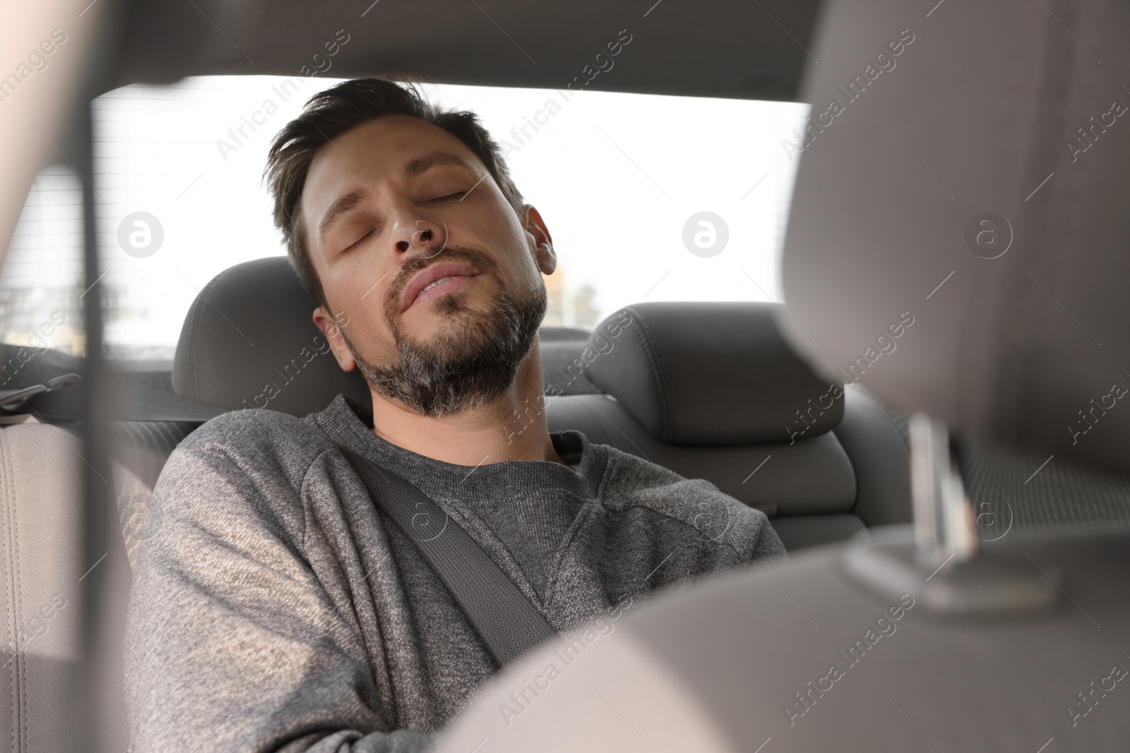 Photo of Tired handsome man sleeping in his car