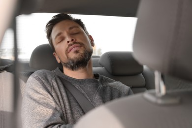 Tired handsome man sleeping in his car