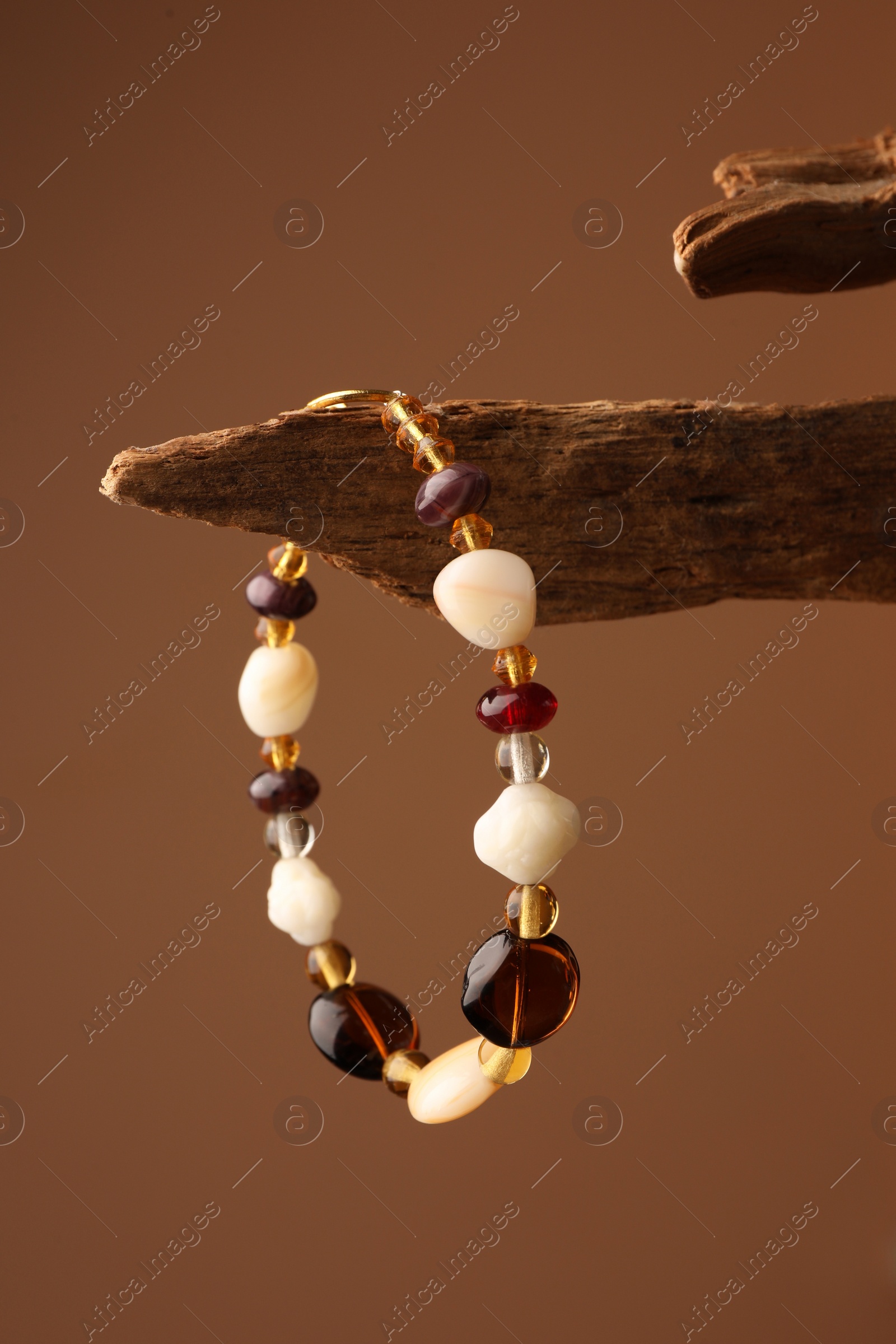 Photo of Stylish presentation of beautiful bracelet with gemstones on brown background