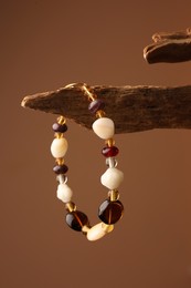Photo of Stylish presentation of beautiful bracelet with gemstones on brown background