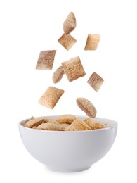 Sweet crispy corn pads falling into bowl with milk on white background 