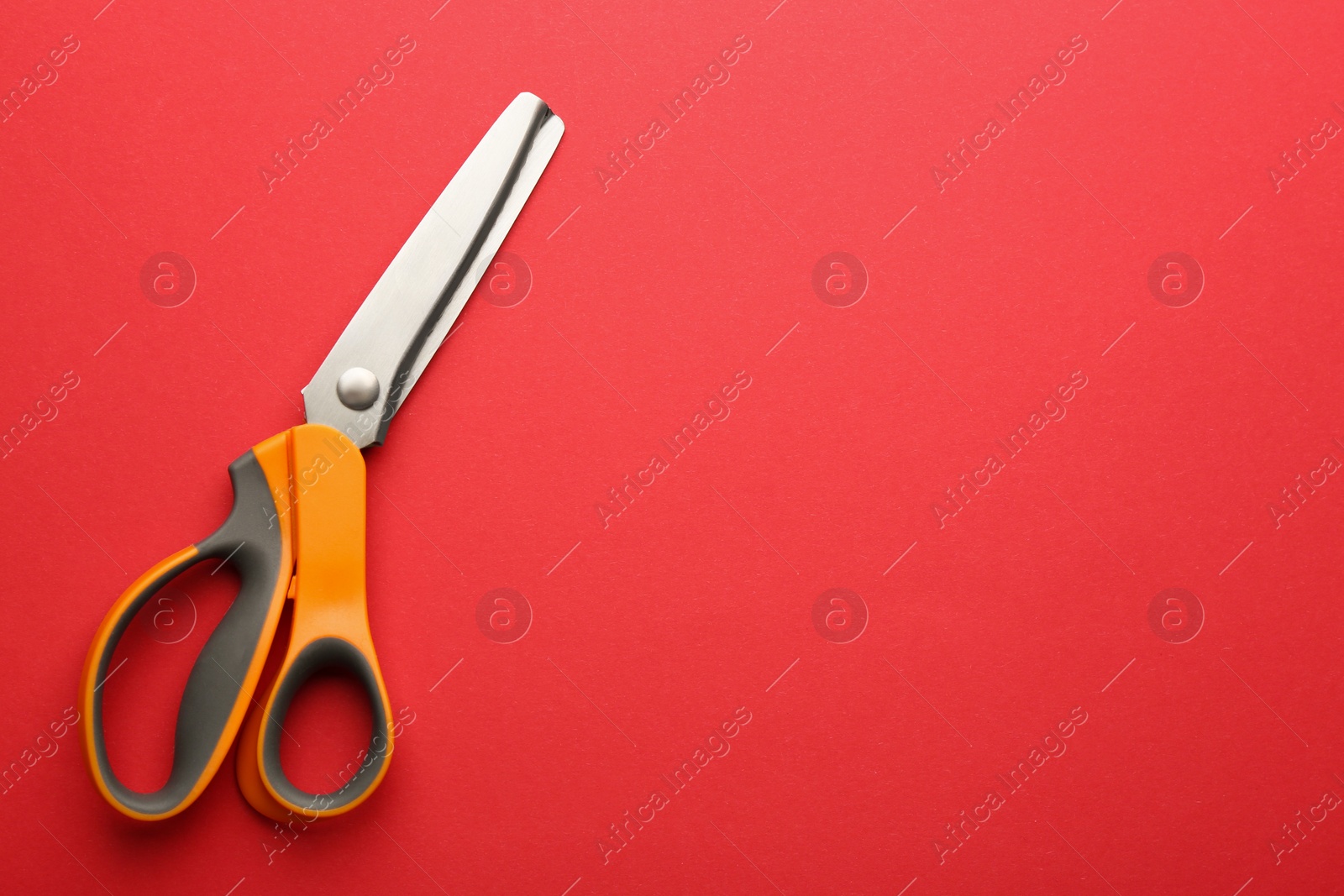 Photo of Pair of sharp scissors on color background, top view. Space for text