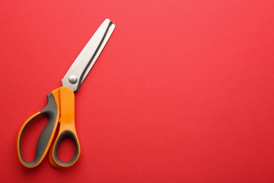 Photo of Pair of sharp scissors on color background, top view. Space for text