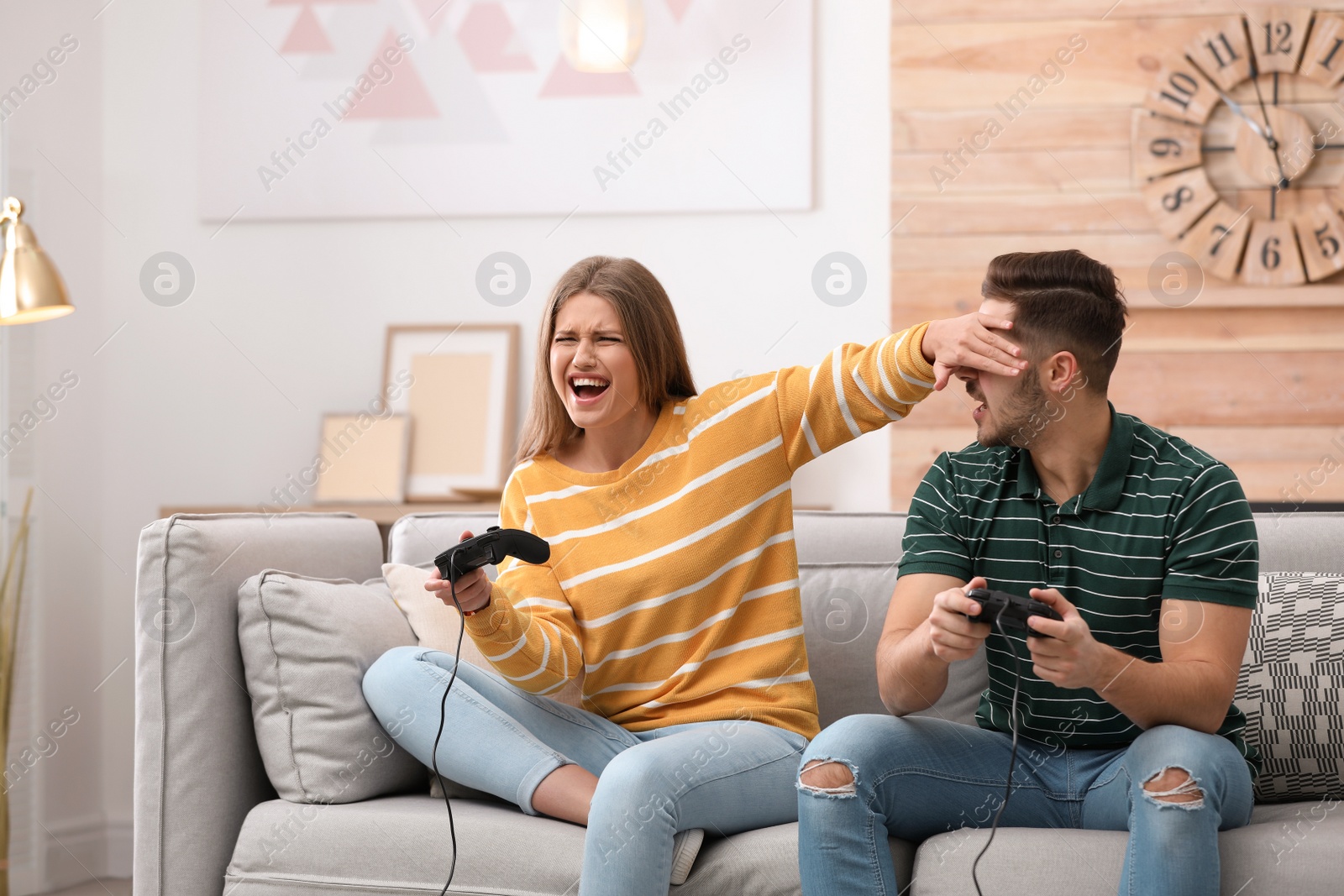 Photo of Emotional young couple playing video games at home