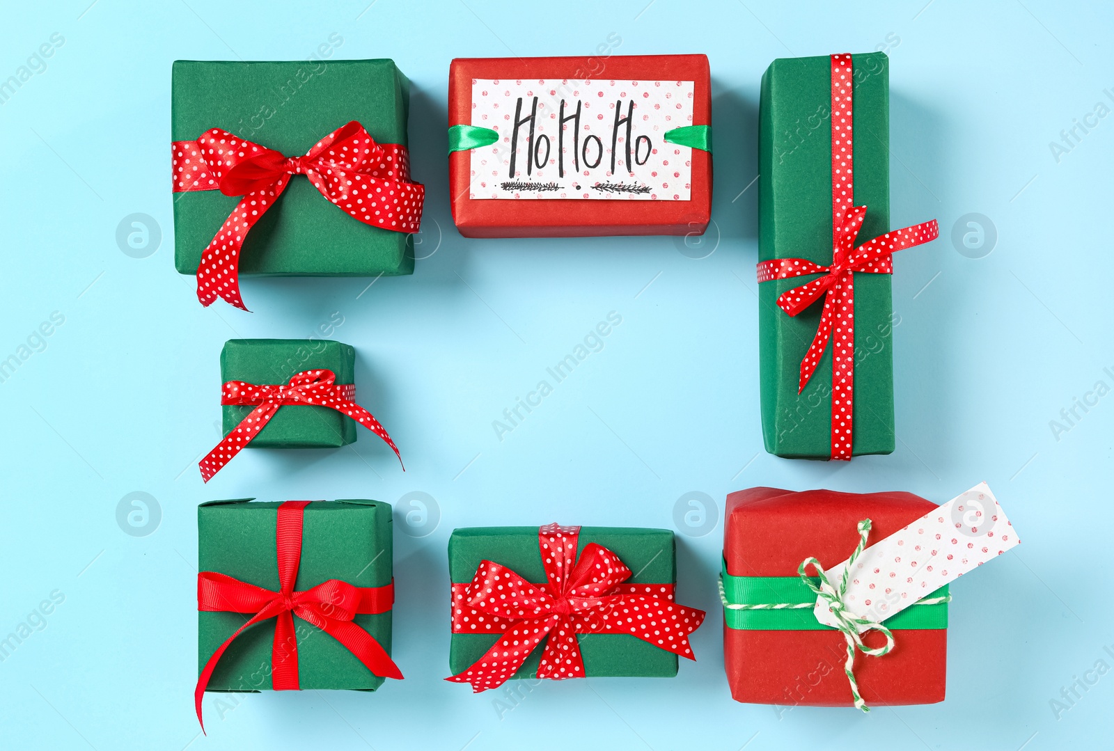 Photo of Frame of Christmas gift boxes on light blue background, flat lay. Space for text