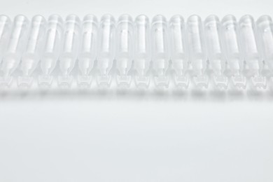 Single dose ampoules of sterile isotonic sea water solution on white background. Space for text