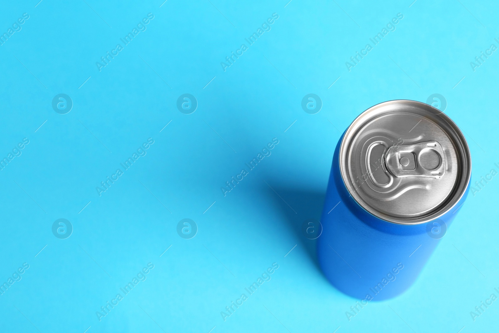 Photo of Energy drink in can on light blue background, above view. Space for text