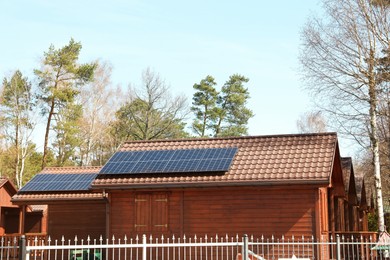 Photo of House with installed solar panels on roof. Alternative energy