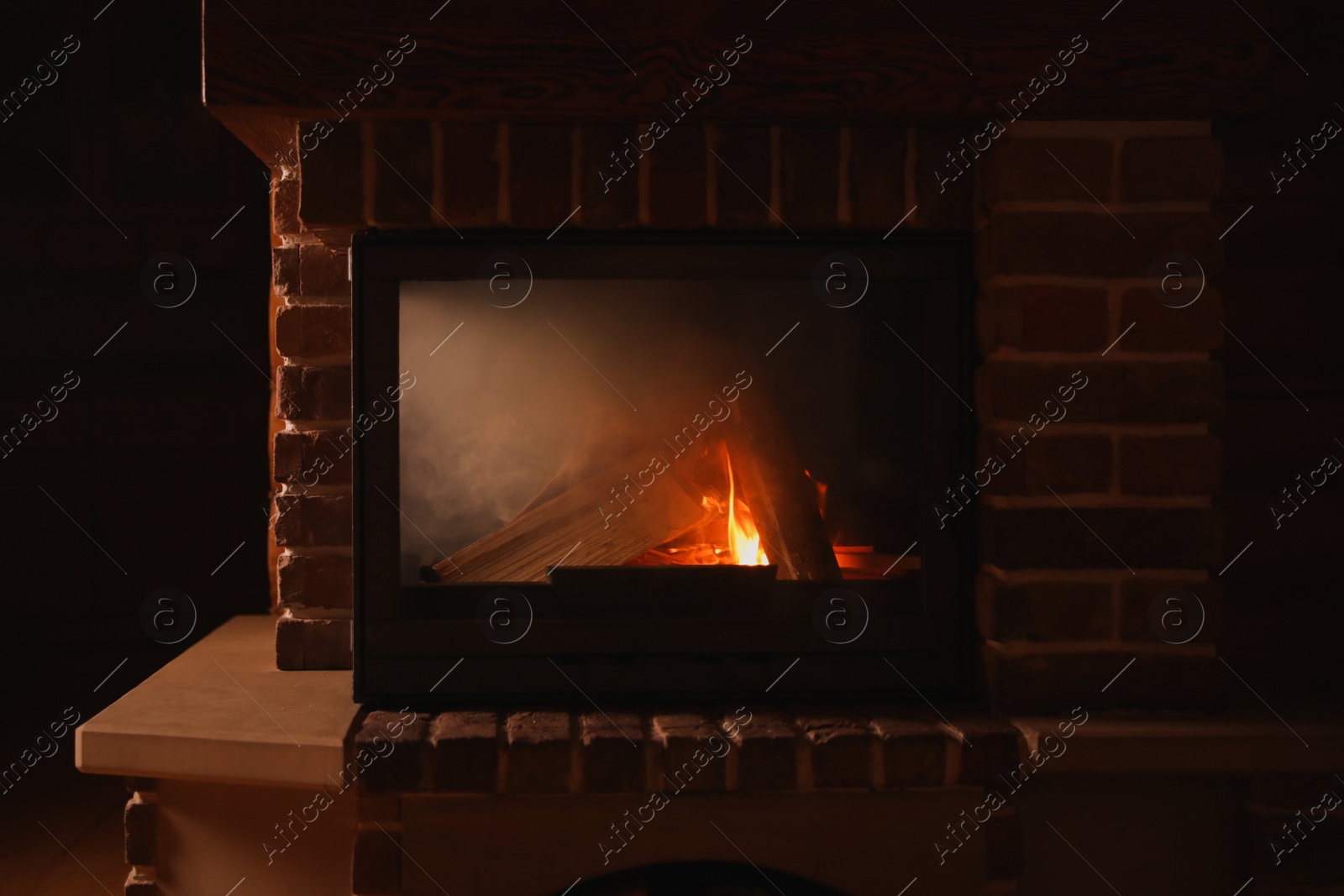 Photo of Contemporary fireplace with wood in cottage, closeup view