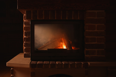 Photo of Contemporary fireplace with wood in cottage, closeup view