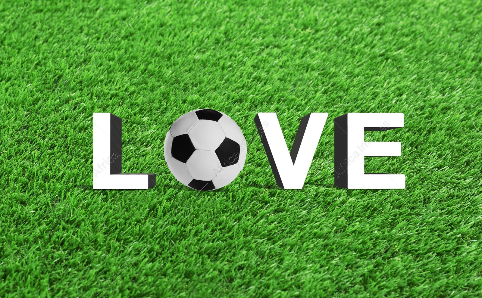 Image of Word LOVE made of letters and soccer ball on green grass