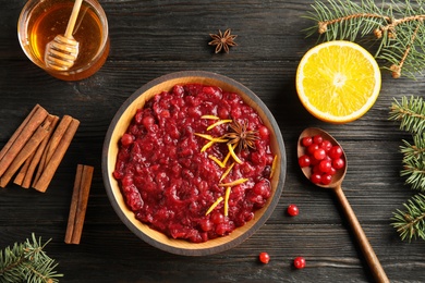Photo of Flat lay composition with cranberry sauce in plate on wooden background