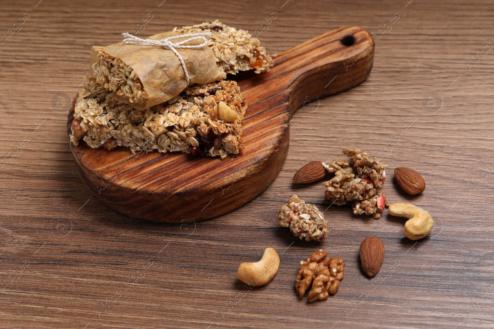 Photo of Tasty granola bars with nuts on wooden table