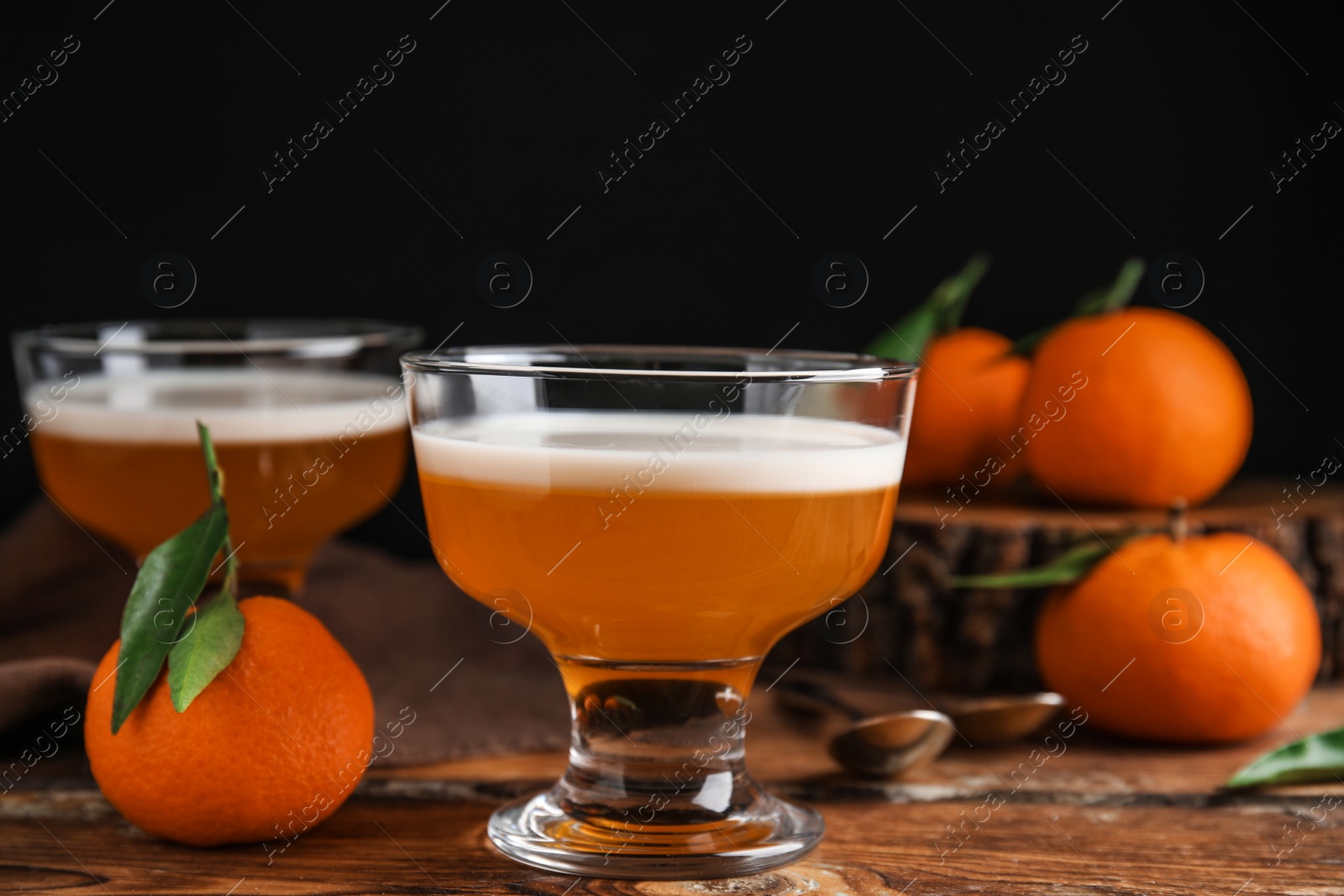 Photo of Delicious tangerine jelly in glass bowl on wooden table, closeup