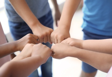 Photo of Little children putting their hands together, closeup. Unity concept