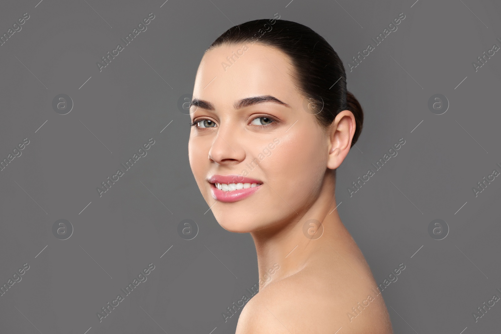 Photo of Portrait of young woman with beautiful face and natural makeup on color background