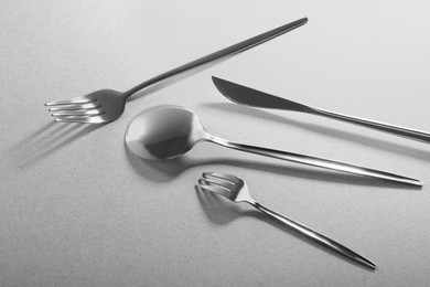 Photo of Forks, knife and spoon on grey background. Stylish cutlery set