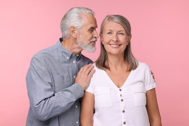 Photo of Portrait of happy affectionate senior couple on pink background