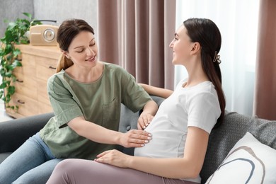 Photo of Doula taking care of pregnant woman at home. Preparation for child birth