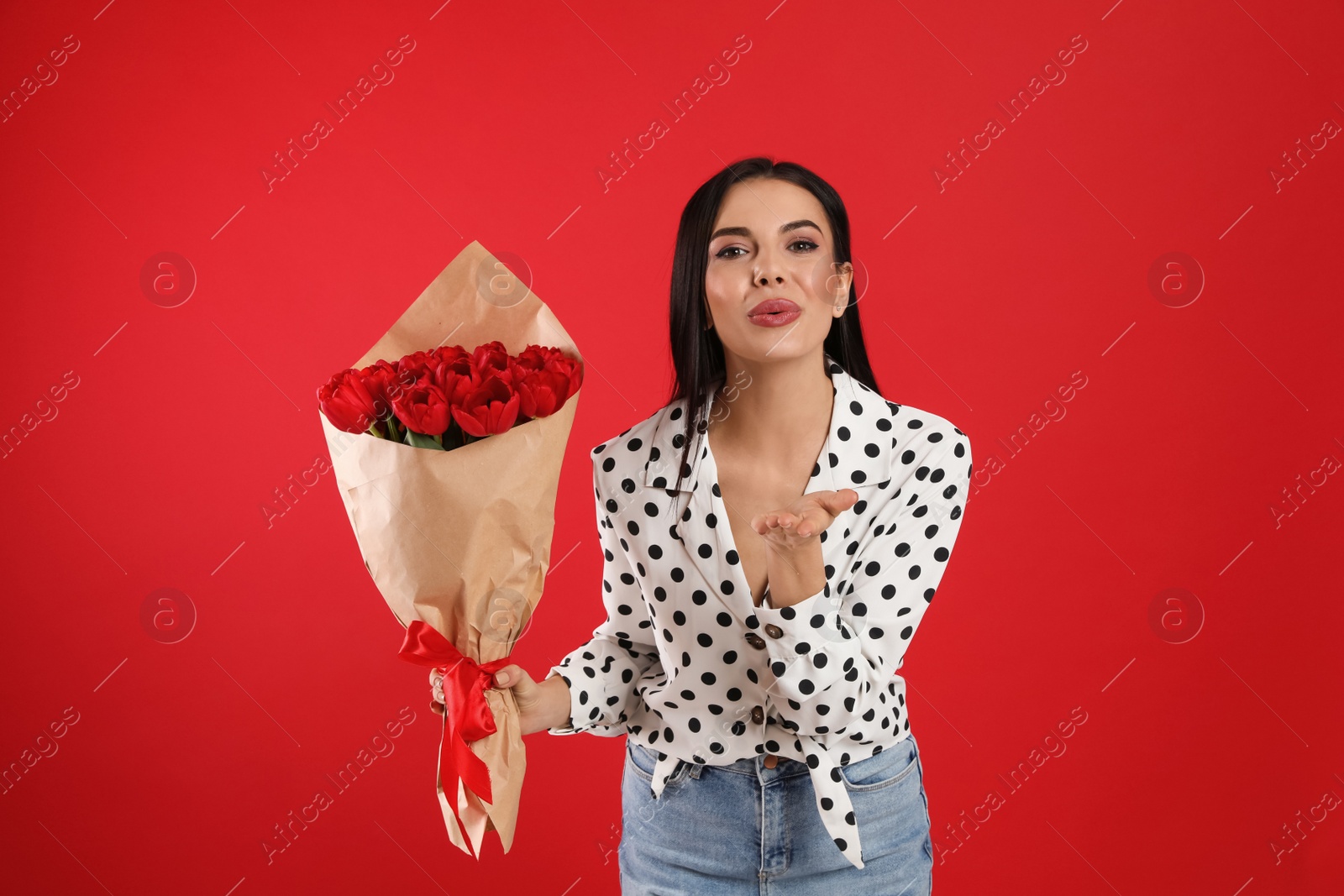 Photo of Happy woman with tulip bouquet on red background. 8th of March celebration