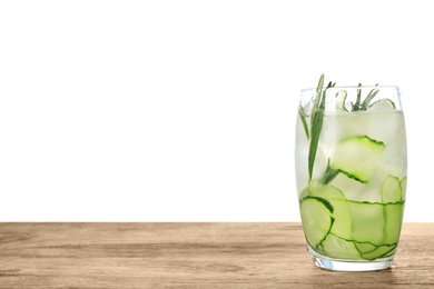 Glass of refreshing cucumber lemonade and rosemary on wooden table against white background. Summer drink