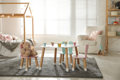 Small table and chairs with bunny ears in children's bedroom interior