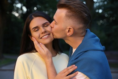 Photo of Affectionate young couple having good time together outdoors