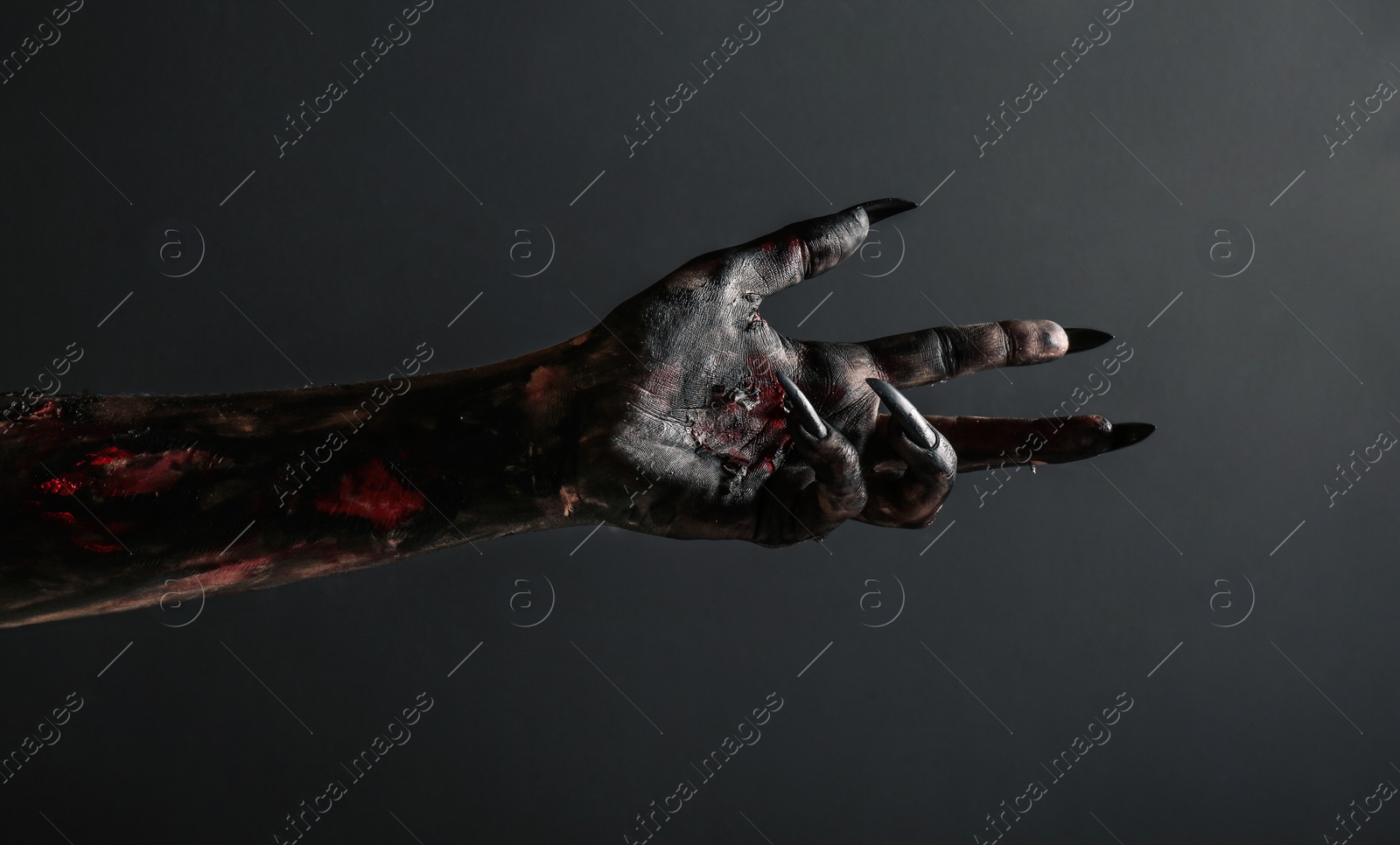 Photo of Scary monster on black background, closeup of hand. Halloween character