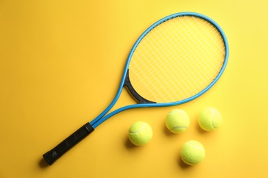 Photo of Tennis racket and balls on yellow background, flat lay. Sports equipment