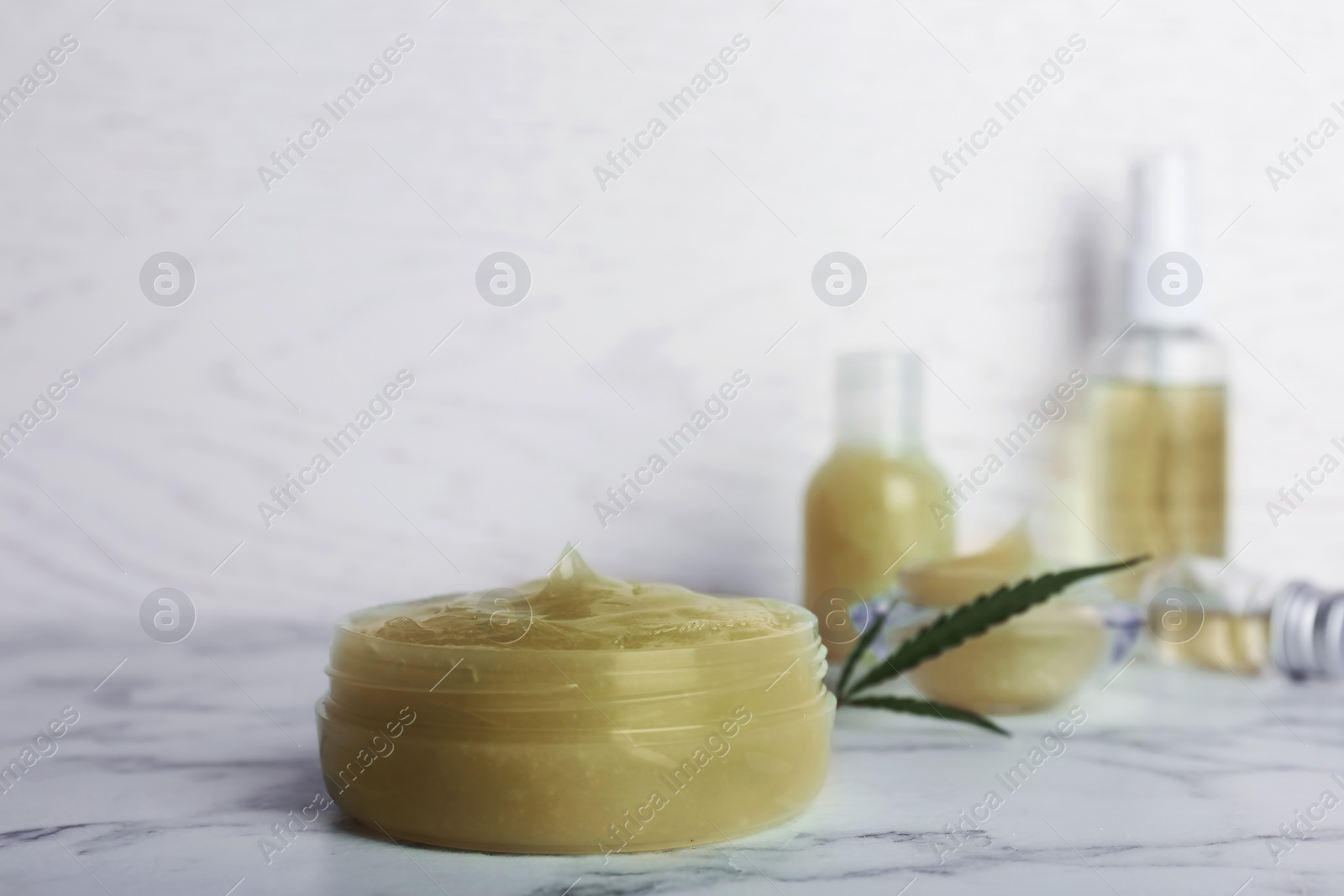 Photo of Jar with hemp lotion on marble table