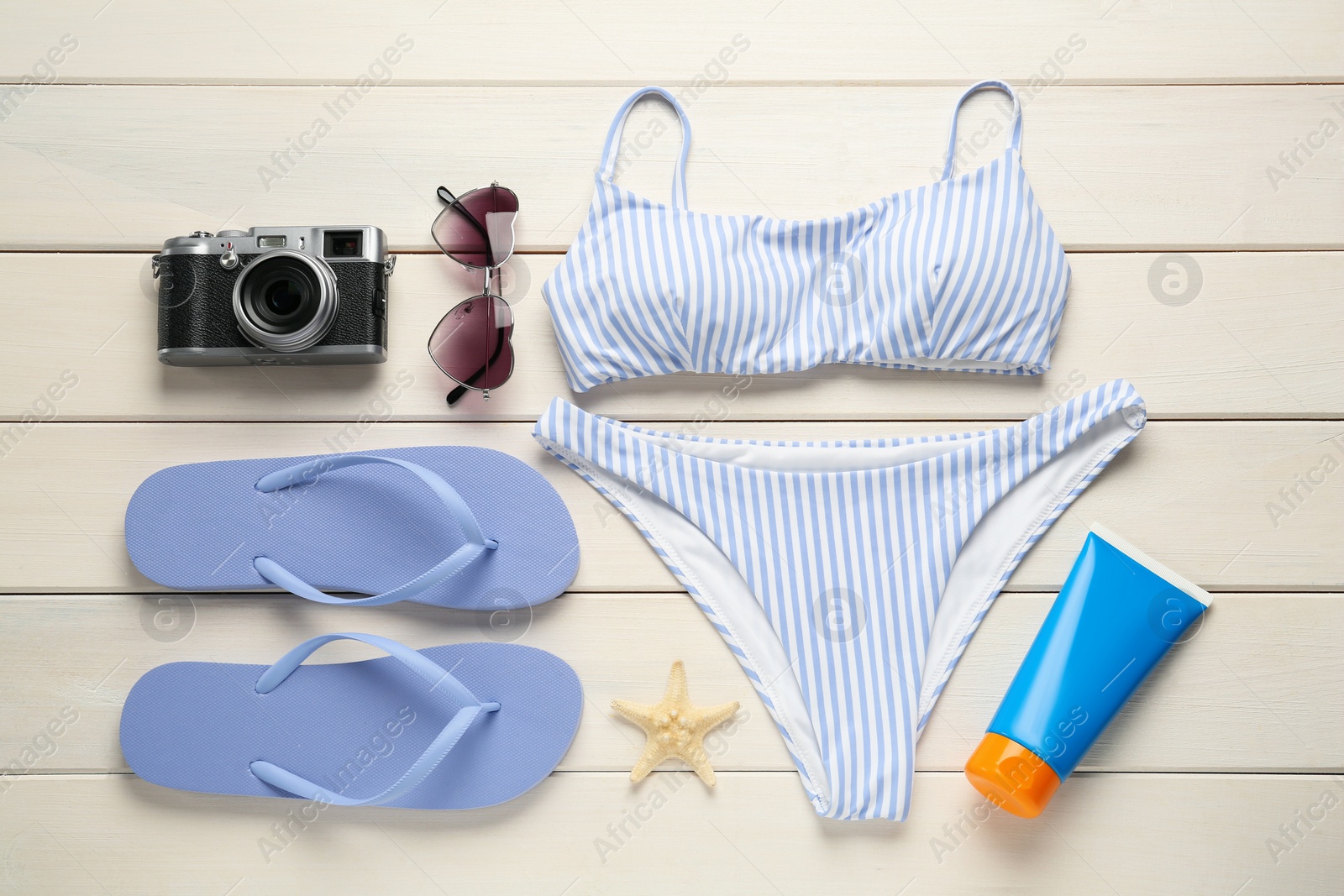 Photo of Different beach objects on white wooden background, flat lay