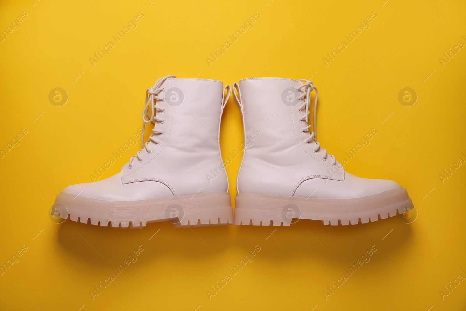 Photo of Pair of stylish shoes on yellow background, flat lay