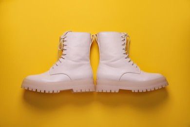 Photo of Pair of stylish shoes on yellow background, flat lay