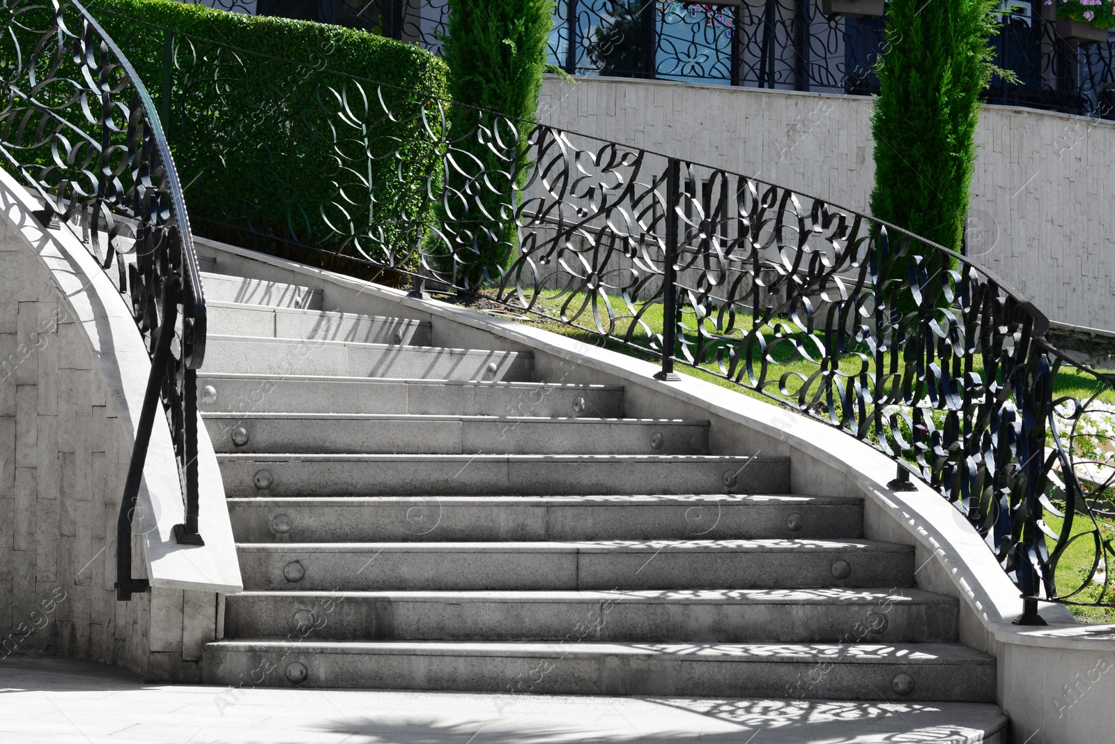 Photo of Staircase with beautiful ornate handrails outdoors on sunny day